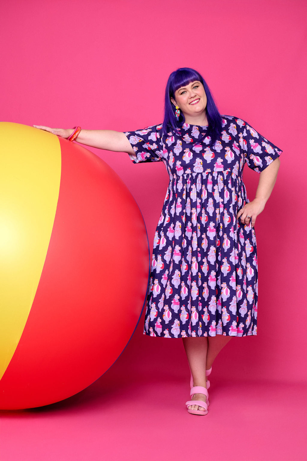 Model wearing Toomi Tess the Hippo cotton midi babydoll dress in colourful hippo print