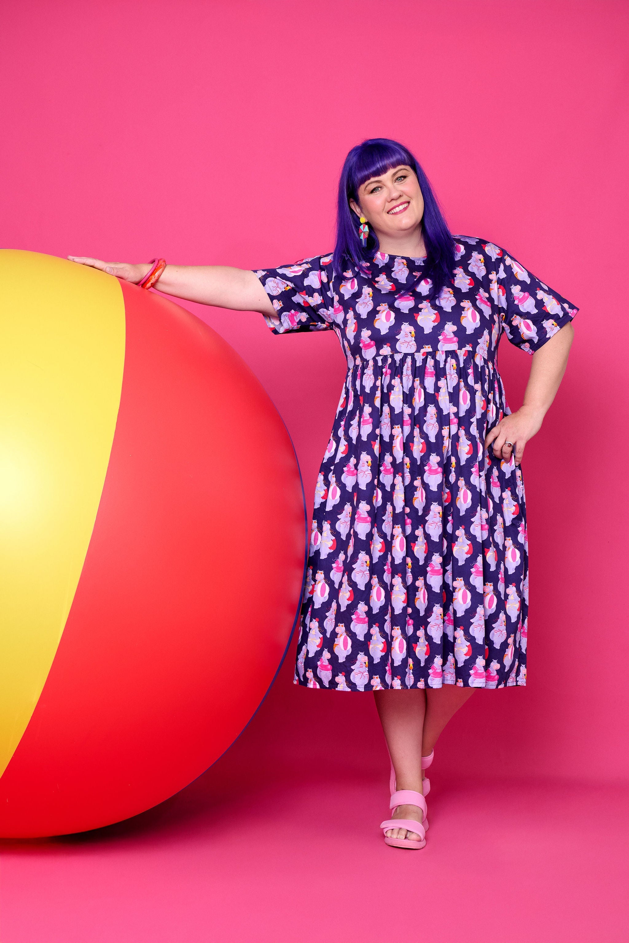 Model wearing Toomi Tess the Hippo cotton midi babydoll dress in colourful hippo print