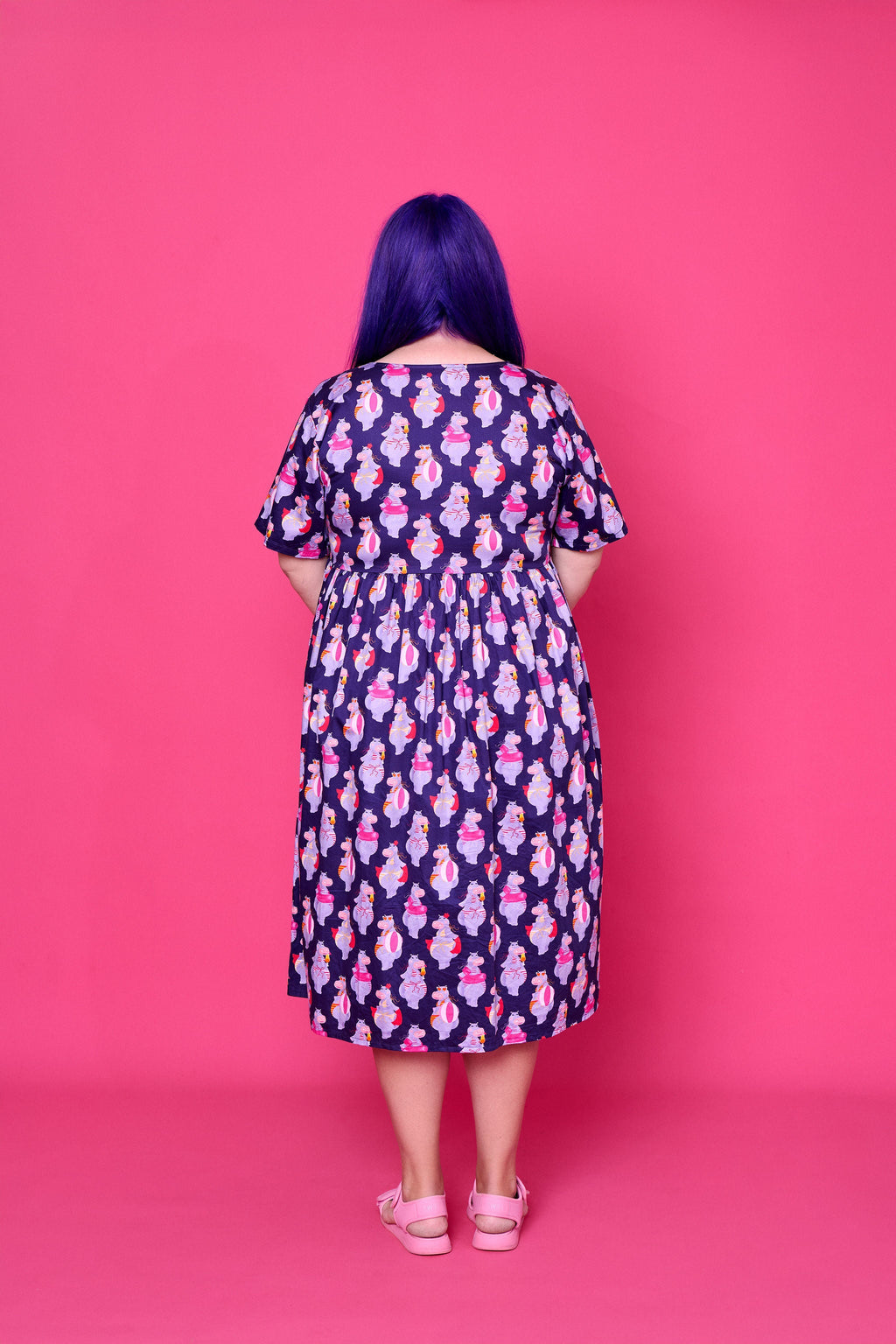 Model wearing Toomi Tess the Hippo cotton midi babydoll dress in colourful hippo print