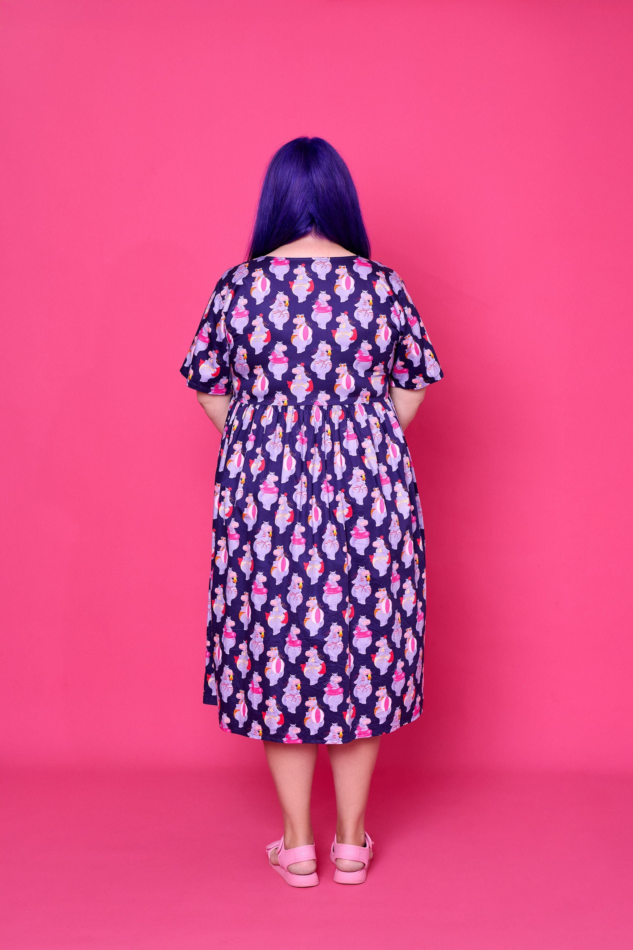 Model wearing Toomi Tess the Hippo cotton midi babydoll dress in colourful hippo print