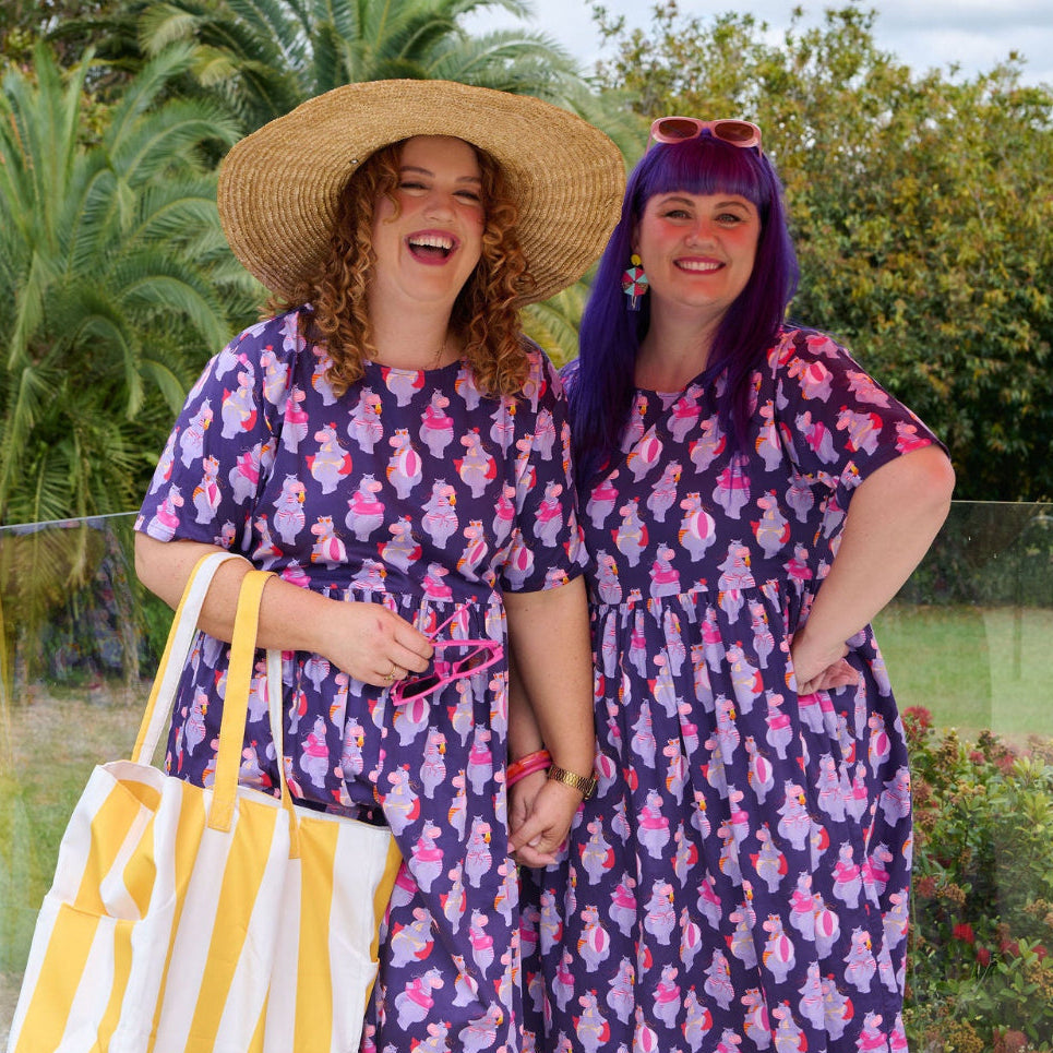 Model wearing Toomi Tess the Hippo cotton midi babydoll dress in colourful hippo print