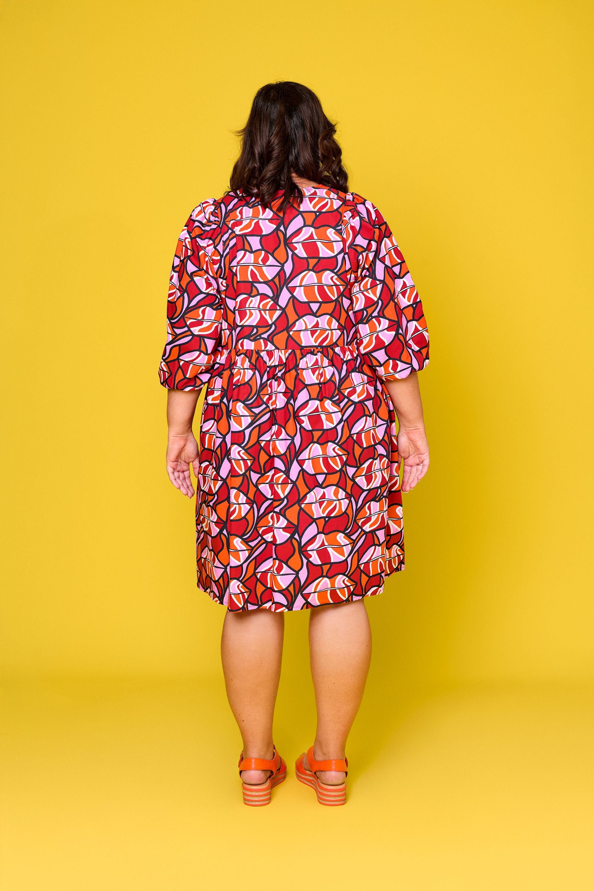 Model wearing Toomi Retro Lips cotton mini babydoll dress in red lips print