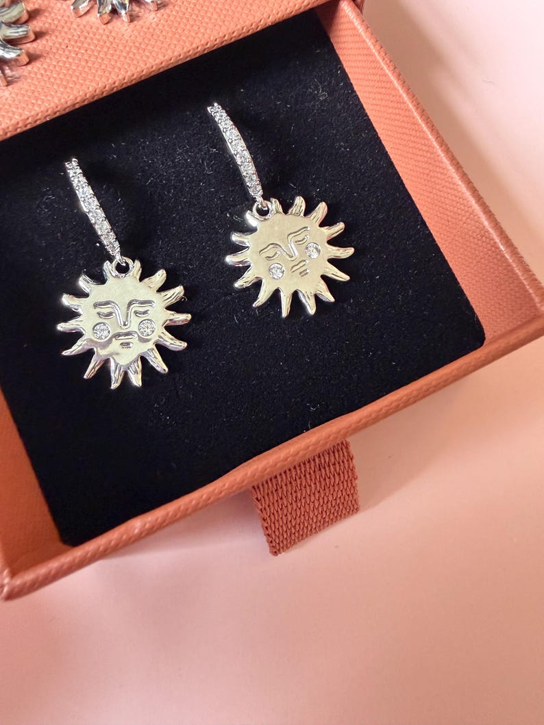 Sun face huggie hoops close up